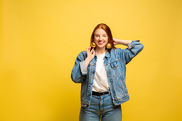 Image showing Caucasian woman\'s portrait isolated on yellow studio background