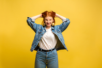 Image showing Caucasian woman\'s portrait isolated on yellow studio background