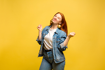 Image showing Caucasian woman\'s portrait isolated on yellow studio background