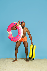 Image showing Happy young man resting on blue studio background