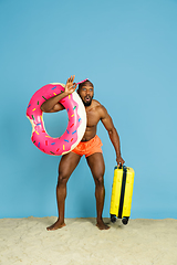 Image showing Happy young man resting on blue studio background