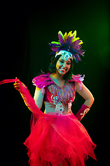 Image showing Beautiful young woman in carnival mask and masquerade costume in colorful lights