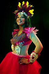 Image showing Beautiful young woman in carnival mask and masquerade costume in colorful lights