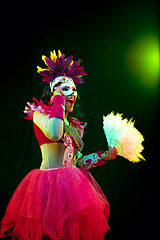 Image showing Beautiful young woman in carnival mask and masquerade costume in colorful lights