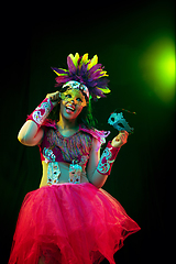 Image showing Beautiful young woman in carnival mask and masquerade costume in colorful lights