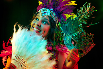 Image showing Beautiful young woman in carnival mask and masquerade costume in colorful lights