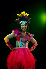 Image showing Beautiful young woman in carnival mask and masquerade costume in colorful lights