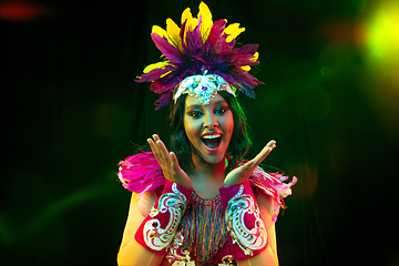 Image showing Beautiful young woman in carnival mask and masquerade costume in colorful lights