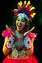 Image showing Beautiful young woman in carnival mask and masquerade costume in colorful lights