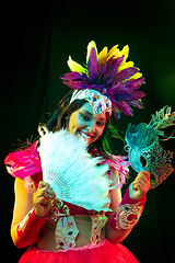 Image showing Beautiful young woman in carnival mask and masquerade costume in colorful lights