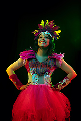 Image showing Beautiful young woman in carnival mask and masquerade costume in colorful lights