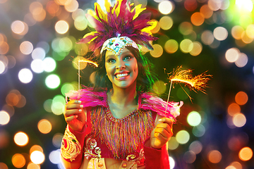 Image showing Beautiful young woman in carnival mask and masquerade costume in colorful lights