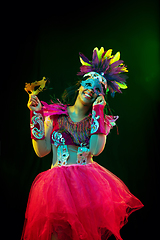 Image showing Beautiful young woman in carnival mask and masquerade costume in colorful lights