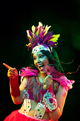 Image showing Beautiful young woman in carnival mask and masquerade costume in colorful lights