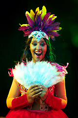 Image showing Beautiful young woman in carnival mask and masquerade costume in colorful lights