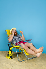 Image showing Happy young man resting on blue studio background