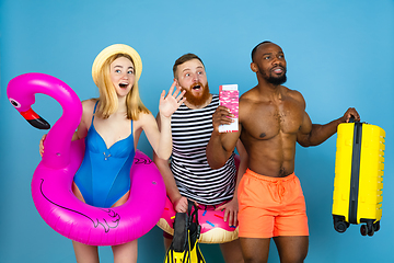 Image showing Happy young friends resting on blue studio background