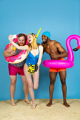 Image showing Happy young friends resting on blue studio background