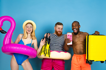 Image showing Happy young friends resting on blue studio background