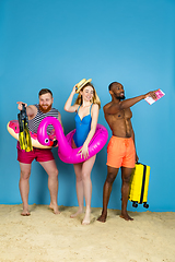 Image showing Happy young friends resting on blue studio background