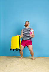 Image showing Happy young man resting on blue studio background