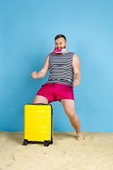 Image showing Happy young man resting on blue studio background