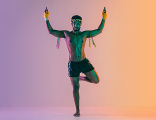 Image showing Muay thai. Young man exercising thai boxing on gradient background