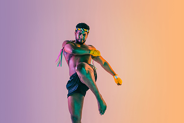 Image showing Muay thai. Young man exercising thai boxing on gradient background