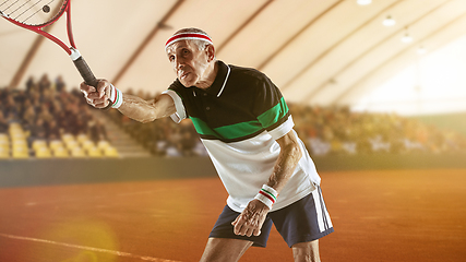 Image showing Senior man playing tennis in sportwear on stadium