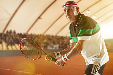 Image showing Senior man playing tennis in sportwear on stadium