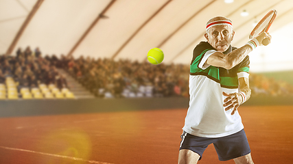Image showing Senior man playing tennis in sportwear on stadium
