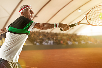 Image showing Senior man playing tennis in sportwear on stadium