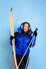 Image showing Caucasian woman\'s portrait isolated on blue studio background, winter theme