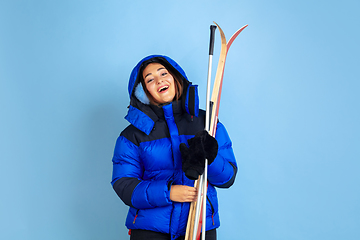 Image showing Caucasian woman\'s portrait isolated on blue studio background, winter theme