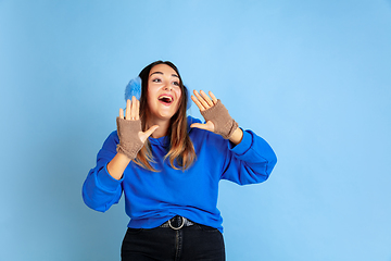 Image showing Caucasian woman\'s portrait isolated on blue studio background, winter theme