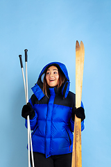 Image showing Caucasian woman\'s portrait isolated on blue studio background, winter theme