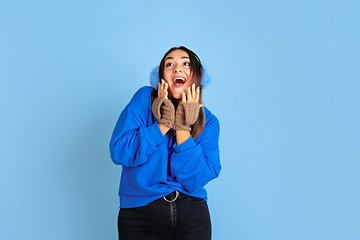 Image showing Caucasian woman\'s portrait isolated on blue studio background, winter theme