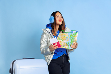 Image showing Caucasian woman\'s portrait isolated on blue studio background, winter theme