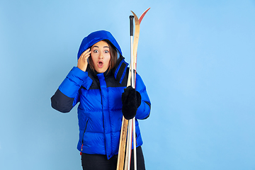 Image showing Caucasian woman\'s portrait isolated on blue studio background, winter theme