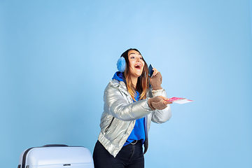 Image showing Caucasian woman\'s portrait isolated on blue studio background, winter theme