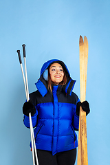 Image showing Caucasian woman\'s portrait isolated on blue studio background, winter theme