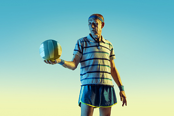 Image showing Senior man playing volleyball in sportwear on gradient background and neon light