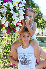 Image showing daughter sitting on her mother and many flowers