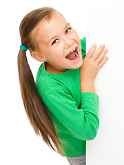 Image showing Little girl is looking from out blank board