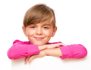 Image showing Little girl is looking out from the blank banner