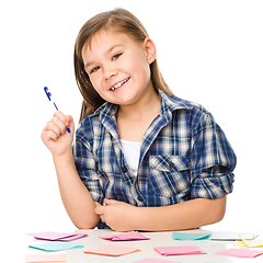 Image showing Girl is writing on color stickers using pen