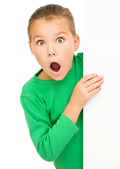 Image showing Little girl is looking out from the blank banner