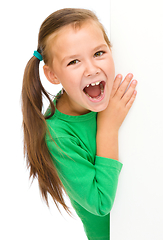 Image showing Little girl is looking from out blank board