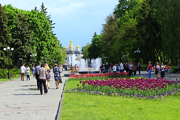 Image showing People have a rest in city park with tulips