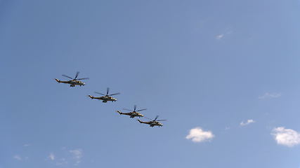 Image showing Combat helicopters Mi-24 fly in blue sky